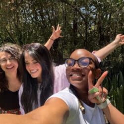 Three people casually posing for a picture, smiling.