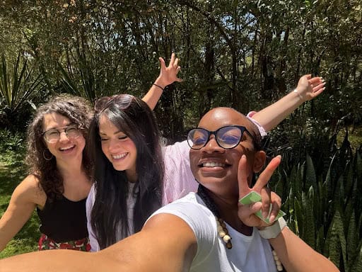 Three people casually posing for a picture, smiling.