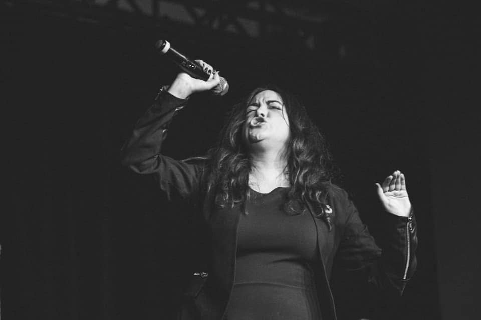 Photo of Lisa J. Smith onstage holding a microphone.