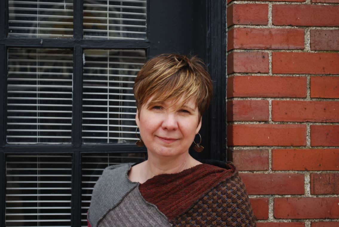 Leslie Wright in front of a brick wall