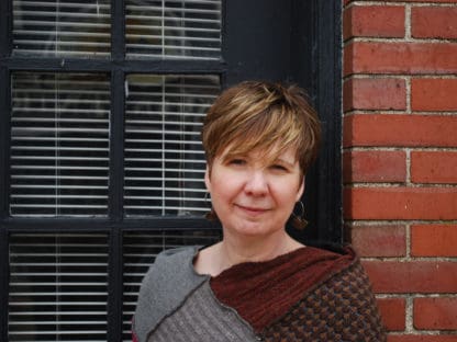 Leslie Wright in front of a brick wall