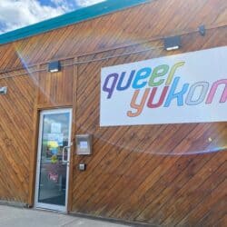 Wood building with a sign "Queer Yukon"