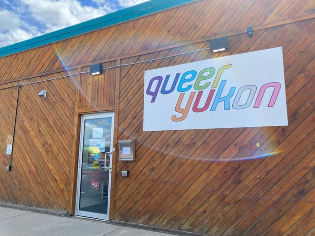 Wood building with a sign "Queer Yukon"