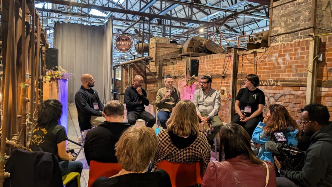 A panel discussion with five people in chairs facing the audience.