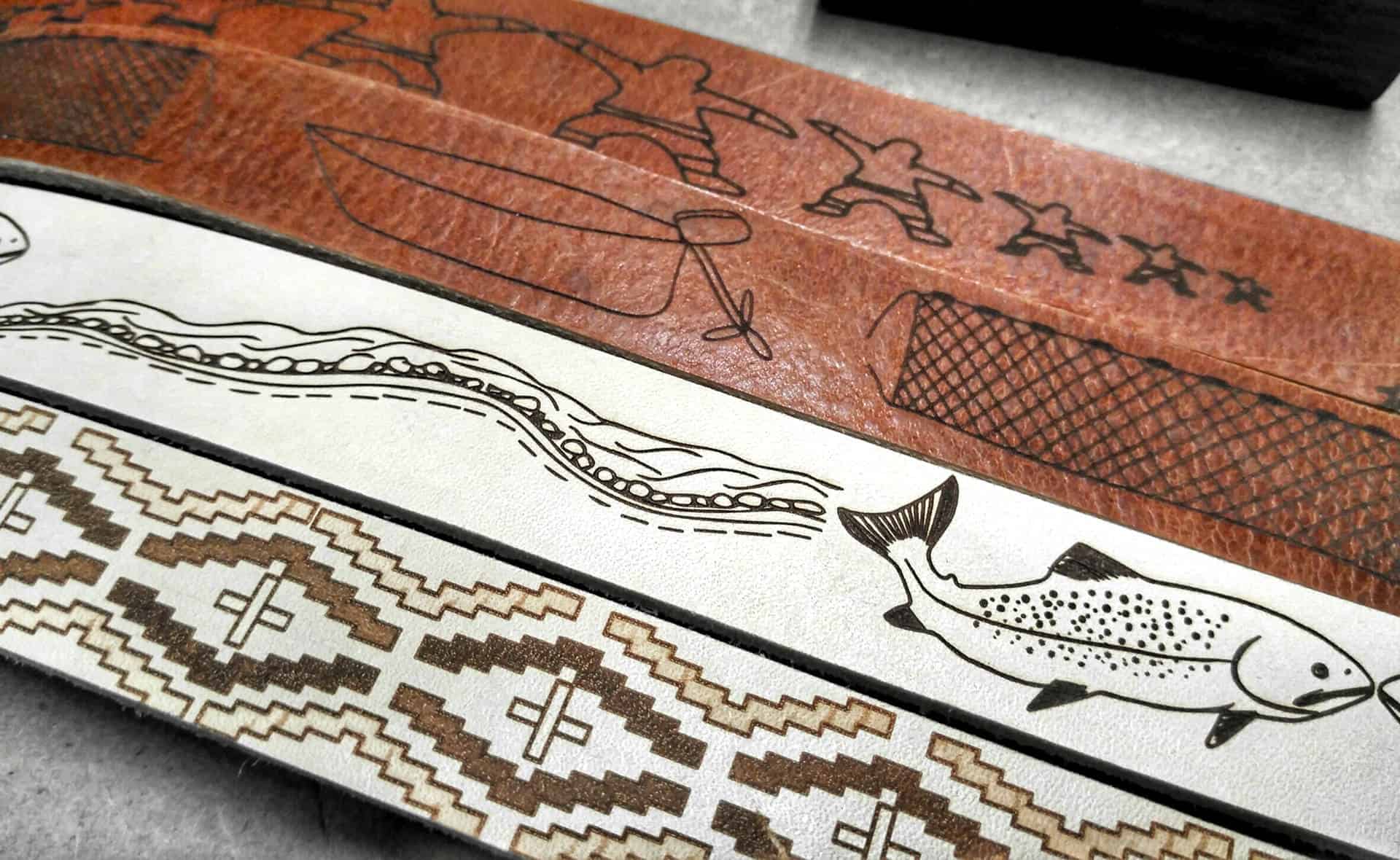 Four belts with images drawn into the leather.